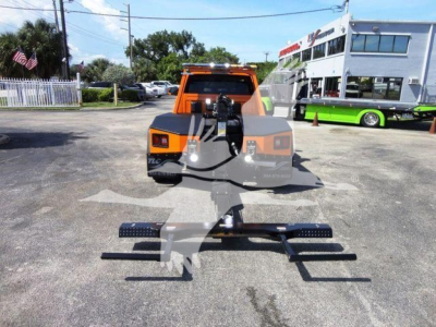Truck with orange cab and winch setup, front view showing heavy-duty bumper and dual step side rails.