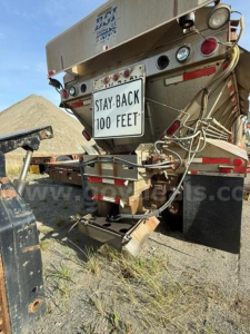 Rear view of 2002 Freightliner FLD120 dump truck showing hydraulic tailgate, warning sign Stay-Back 100 Feet, bumper lights, and wiring harnesses.