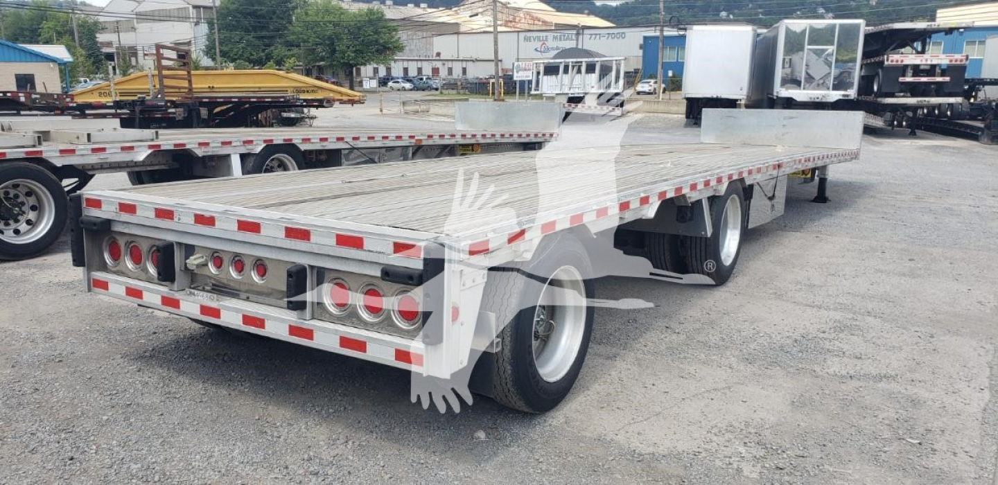 2018 Reitnouer Dropmiser trailer side/rear view showing flatbed with aluminum deck, tandem axles, rear lights, and reflective tape.