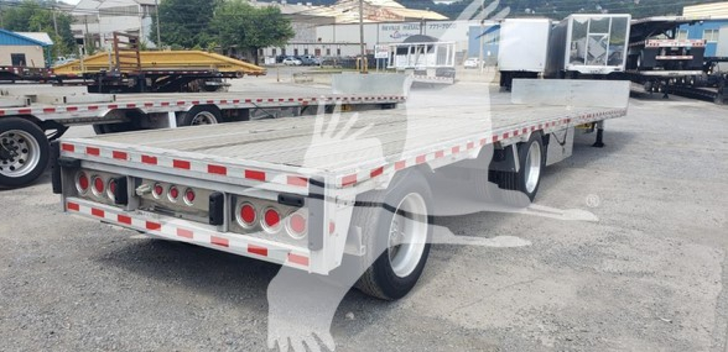 Flatbed trailer showing drop deck with reflective tape and rear lights, 2018 Reitnouer Dropmiser, steel frame, dual rear axles