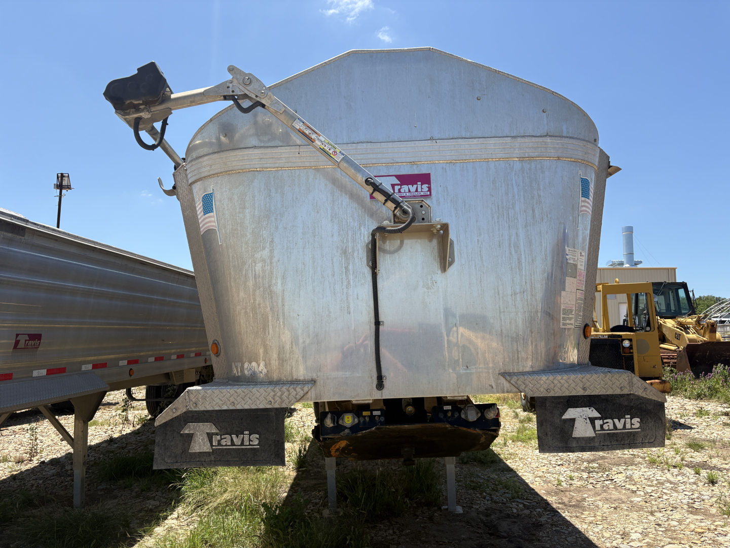 Trailer dump body rear view showing tailgate and Travis brand mudflaps.