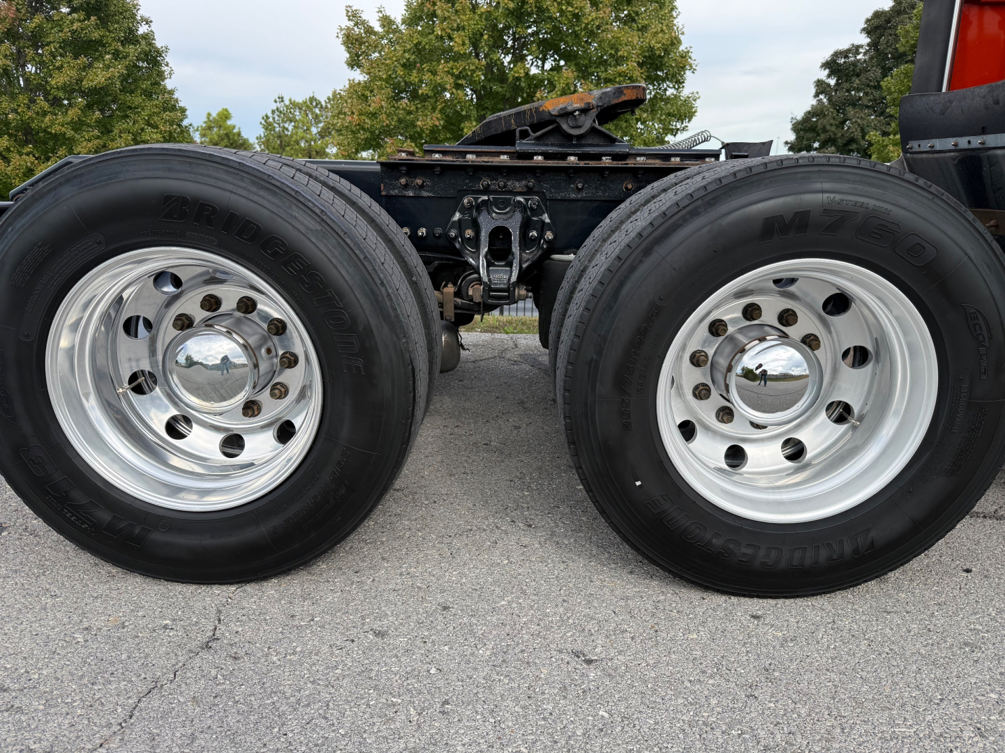 Kenworth T680 chassis showing dual rear wheels and leaf-spring suspension with chrome hubcaps.
