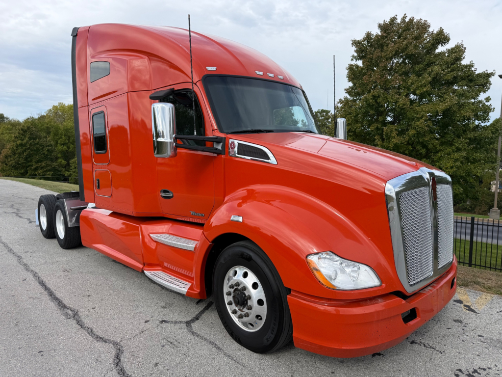 Kenworth T680 2021 conventional sleeper truck in red, side view showing front grille, bumper, and dual rear axles.