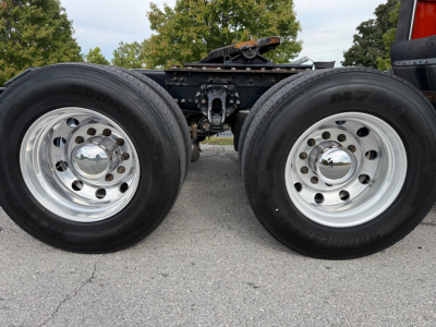 Kenworth T680 chassis showing dual rear wheels and leaf-spring suspension with chrome hubcaps.
