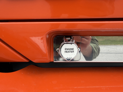 Kenworth T680 fuel cap area showing engine heater cap in orange paint