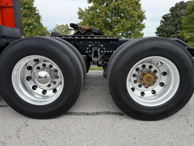 Kenworth T680 wheel area showing dual rear axles with polished chrome rims, tires, and brake components. No legible labels visible on tires.