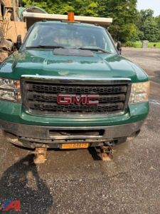 Front view of a green 2012 GMC Sierra 3500 dump truck showing GMC grille and bumper.