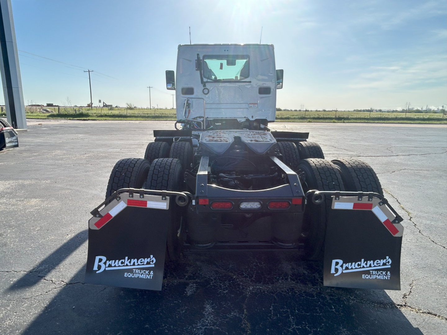 Conventional daycab truck chassis rear view showing dual rear axle setup with mud flaps labeled Bruckner's Truck Equipment.