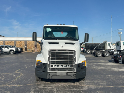 Front view of a white 2027 Mack AN64T daycab with large grille and black bumper, showing Mack emblem, headlights, and side mirrors.