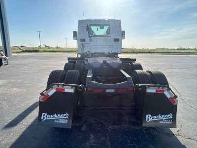 Conventional daycab truck chassis rear view showing dual rear axle setup with mud flaps labeled Bruckner's Truck Equipment.