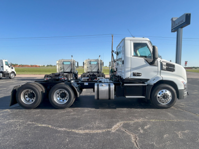 Truck side view showing Mack AN64T chassis with sleeper cab, standard wheels and dual rear axles, chrome fuel tanks, and front grille details.