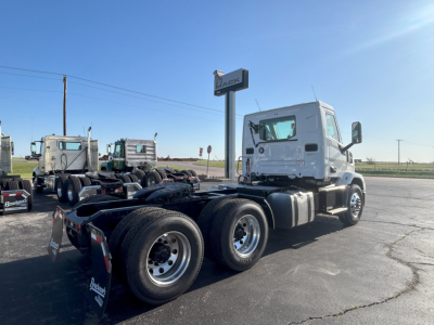Mack AN64T tractor cab in a dealership lot showing front and side view with six-wheel configuration and white cab.