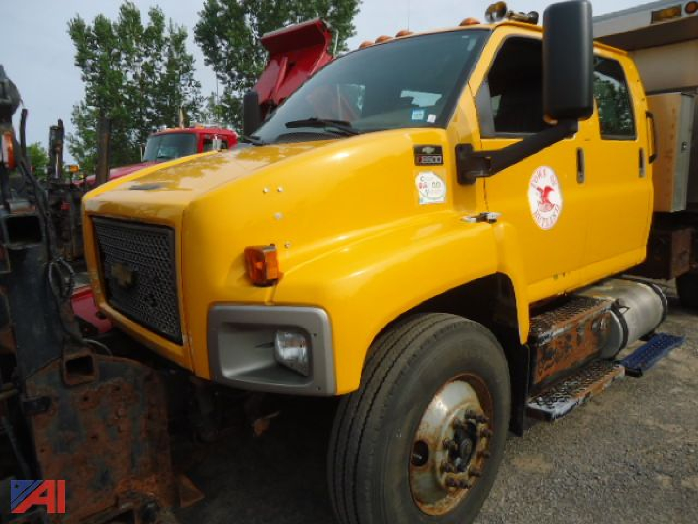 Chevrolet Kodiak C8500 dump truck with plow and yellow cab, side view showing front bumper, grille, and right-side steps.