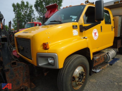 Chevrolet Kodiak C8500 dump truck with plow and yellow cab, side view showing front bumper, grille, and right-side steps.