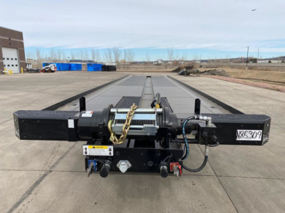 Container trailer hitch assembly with hydraulic winch and control cables showing central beam and mounting hardware.