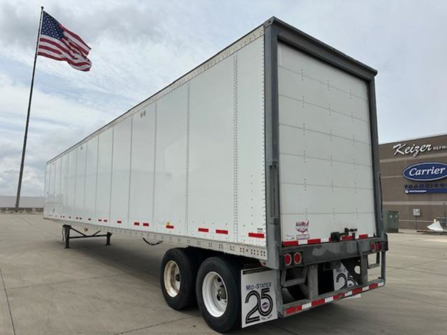 Trailer side and rear of a 2017 Wabash van trailer showing dual rear axles, white aluminum walls, and rear doors.