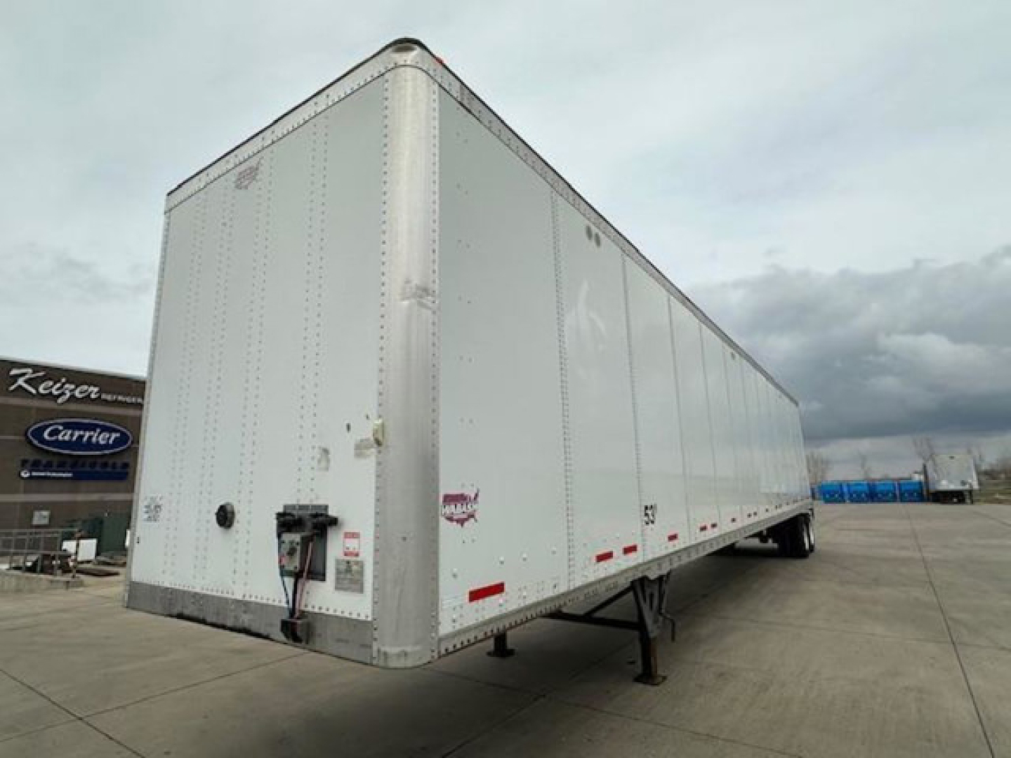 Trailer shows an empty white 2017 Wabash van trailer with swing-out nose and landing gear, side view with registration stickers and wheel area visible.