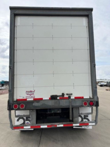 Rear view of a 2017 Wabash trailer with closed vertical liftgate, showing taillights, bumper, and reflective stripes. VIN tag and stock number not visible clearly.