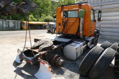 Volvo VNM42T truck tractor rear view showing cab, exposed drivetrain, and multiple wheel assemblies.
