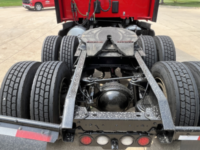 Kenworth T680 rear view showing dual rear axles and fifth-wheel hitch with frame and suspension components visible.