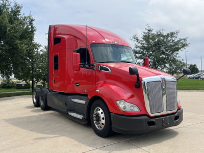 Kenworth T680 sleeper tractor in red, side profile view with chrome grille and black bumper, standard wheels, highway lot background.