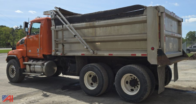 Dump truck side profile showing orange cab and gray dump bed with dual rear axles and hydraulic lift.