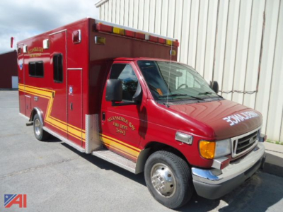 Ford E-450 ambulance truck showing bright red body with yellow striping and white lettering on the side and front.