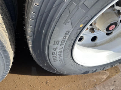 Trailer tire with visible tread and wheel; sidewall shows 'MRL24.5' or 'MR245' and 'SAGIO LGD??' text; part of rim and hub present.