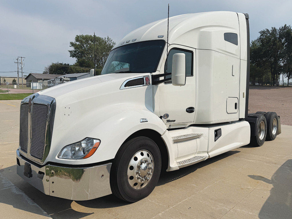 Kenworth T680 tractor in white showing front grille, cab with sleeper, front fender, and chrome bumper. No visible labels or stickers legible.