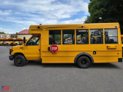 School bus side view showing yellow Ford E-Series body and stop sign on bus