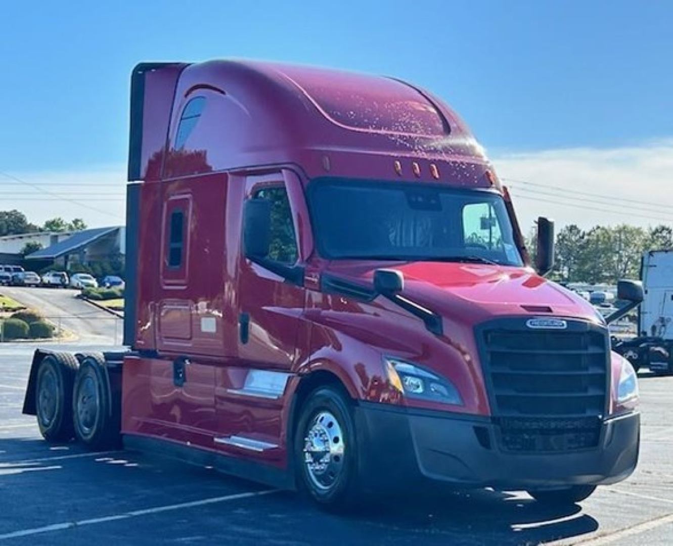 Freightliner Cascadia 126 sleeper cab truck in red, front three-quarter view.