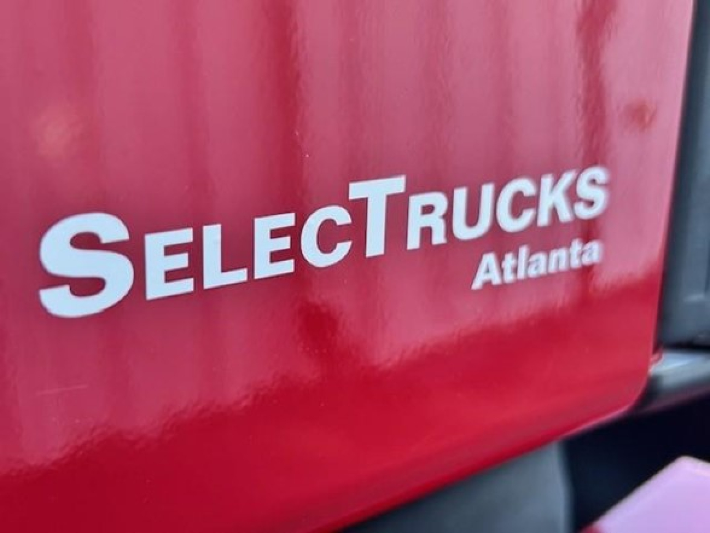 Image shows a red Freightliner truck with SelectTrucks Atlanta logo on the side panel.