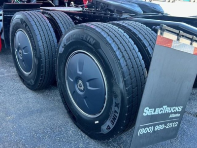 Front wheels and dual rear tires of a Freightliner Cascadia 126 truck showing Michelin X One tires and wheel covers.