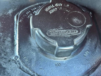 Freightliner Cascadia engine bay view showing: fuel tank cap and nearby markings.