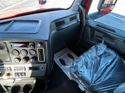 Cab interior of a Freightliner Cascadia truck showing dashboard controls and steering area.