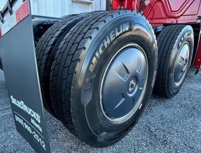 Michelin tires on Freightliner Cascadia 126 truck showing dual rear axles and wheel rims.