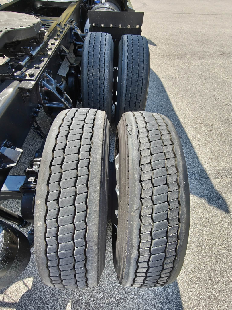 Two rear drive tires on Kenworth T680 chassis with dual axle setup, showing tread pattern and wheel alignment.