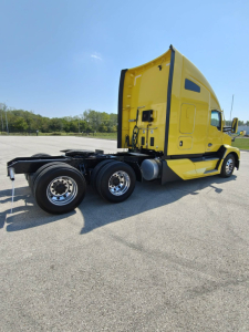 Kenworth T680 tractor truck in yellow, side view, with sleeper cab and three rear wheels visible; chassis and fuel tanks visible under cab; no readable serials or stickers.