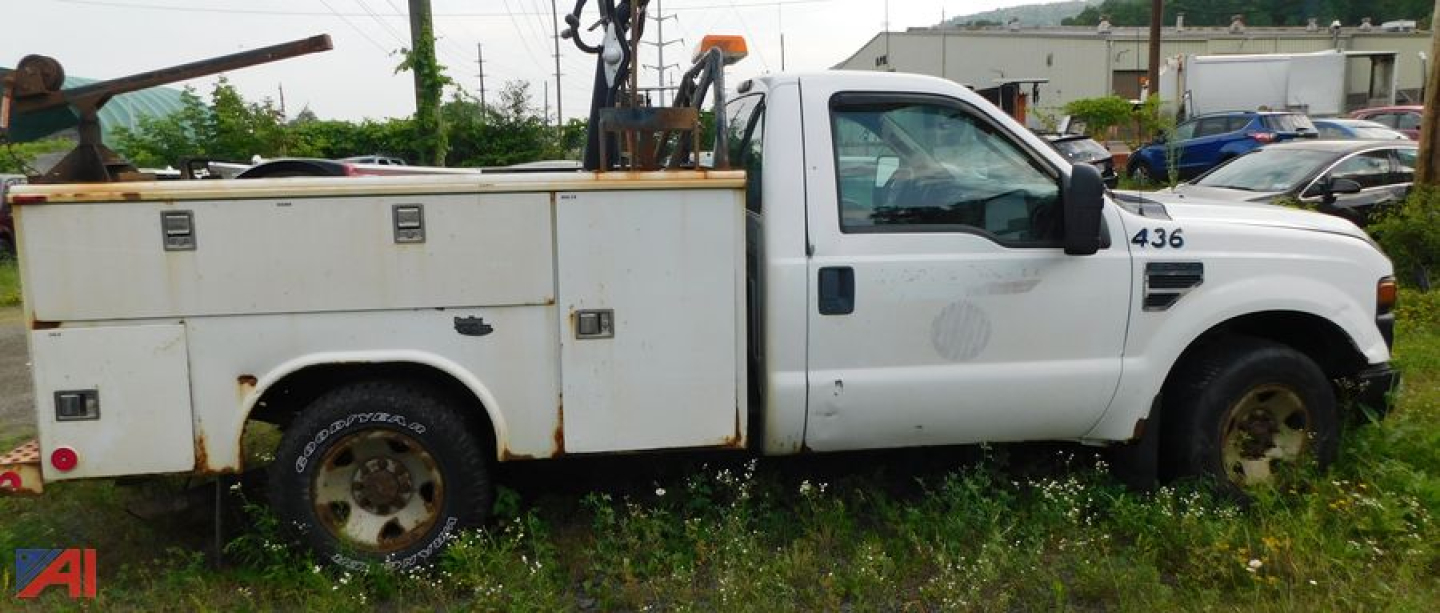 Ford F-250 Super Duty pickup with utility box in service use, side view showing white utility truck with compartments and ladder rack.