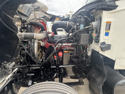 Truck engine bay of a 2020 Mack PI64T showing engine components, hoses, and wiring in the front chassis area.