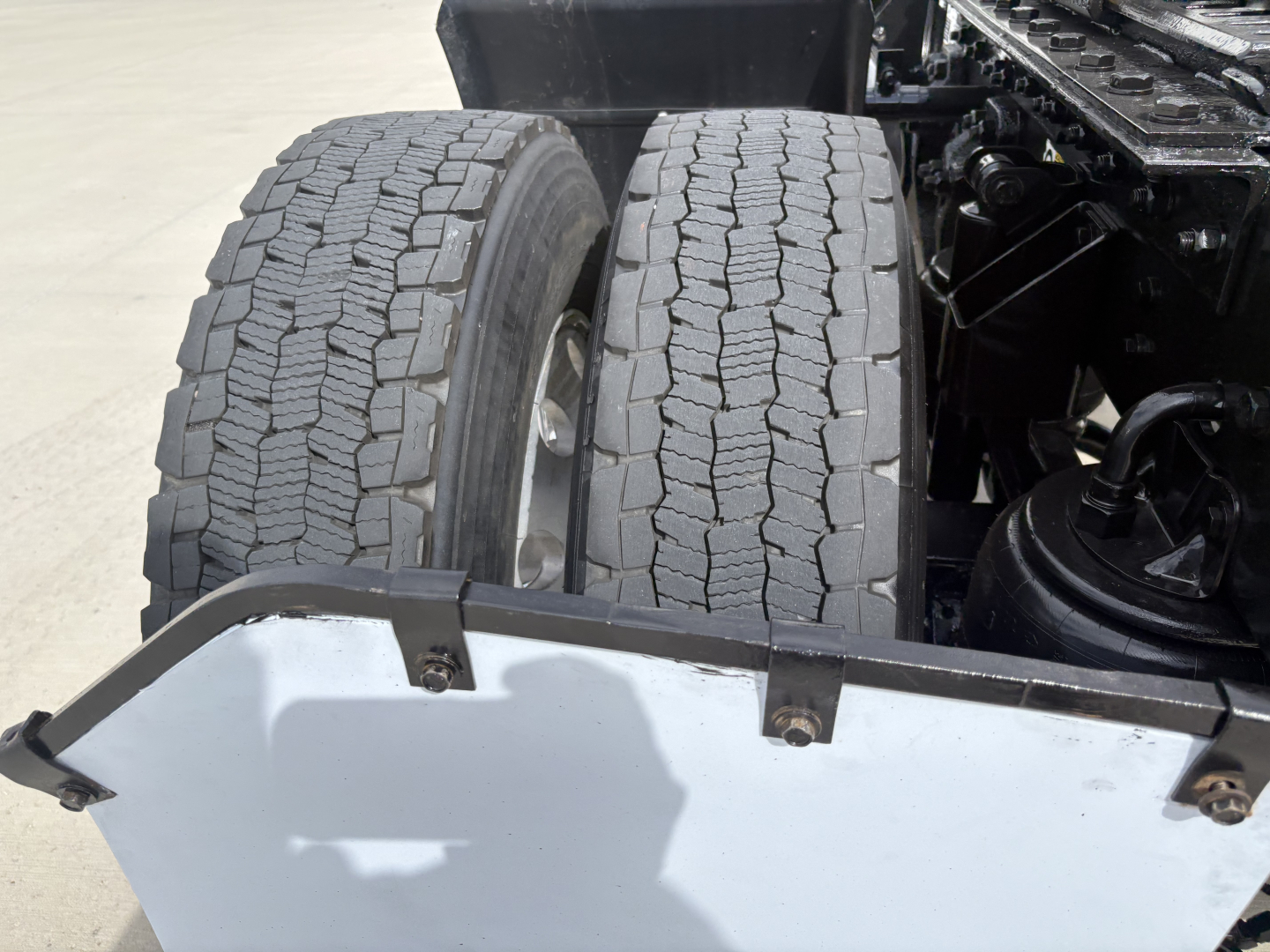 Kenworth T880 dual rear tires and chassis area showing rear wheel wells and chassis components.