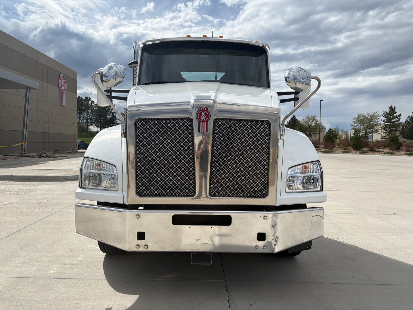 Kenworth T880 conventional daycab truck front view showing large chrome grille, headlights, and bumper.