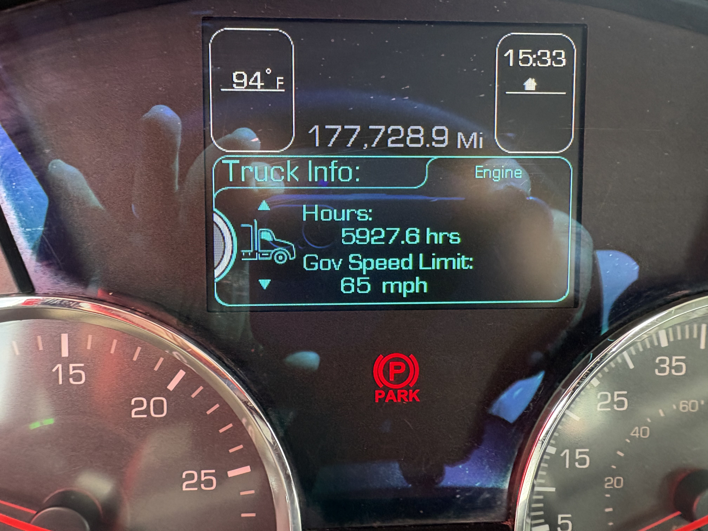 Kenworth T880 cab interior display showing 177,728.9 miles, 5927.6 hrs, Gov Speed Limit 65 mph, and 94°F outside with 15:33 time.