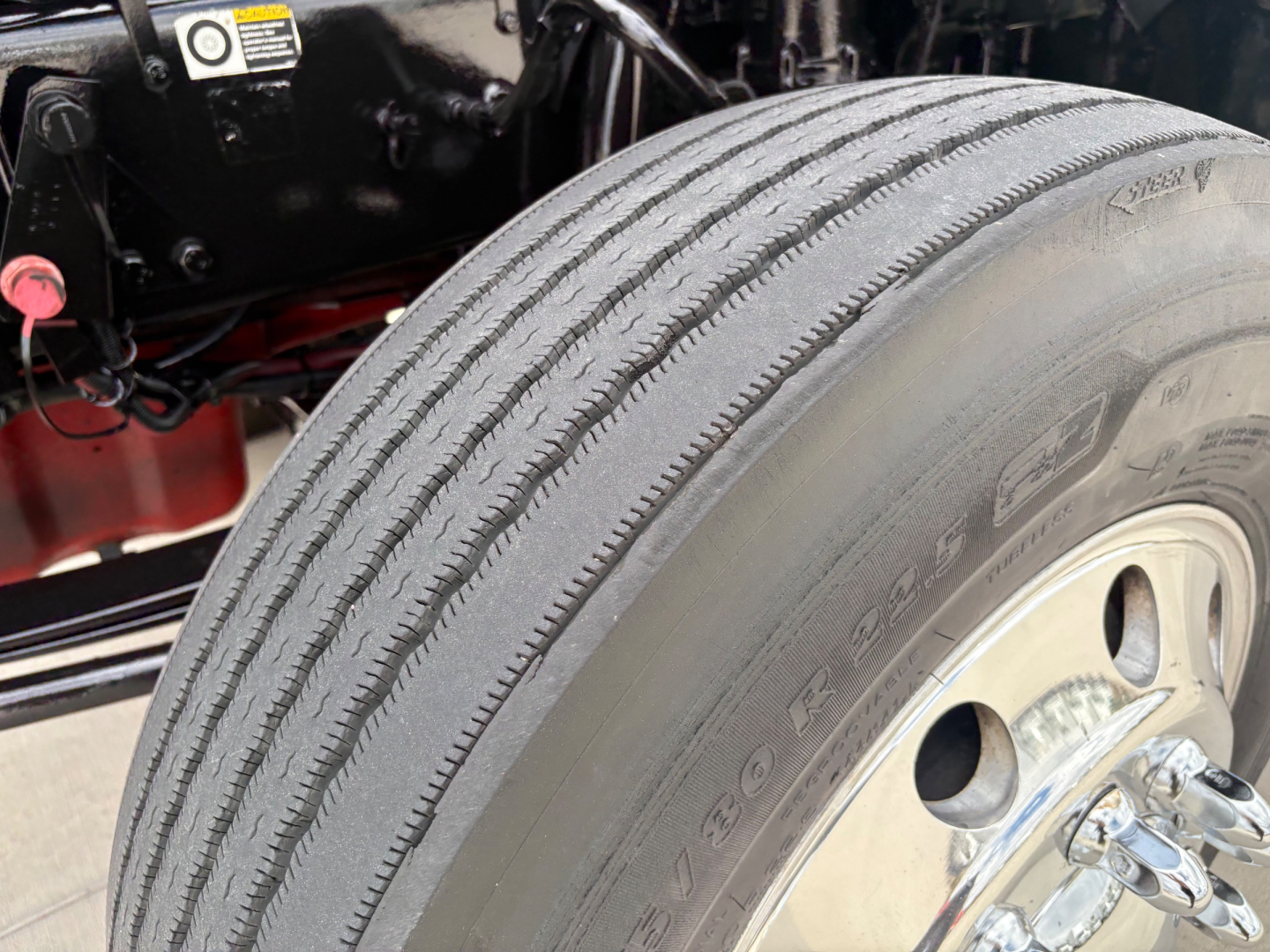 Kenworth T880 wheel and front tire view in a truck cab chassis showing tire tread and wheel assembly