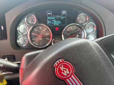 Kenworth T880 dashboard and steering wheel with KW emblem, gauges and digital display.