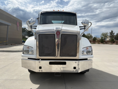 Kenworth T880 conventional daycab truck front view showing large chrome grille, headlights, and bumper.
