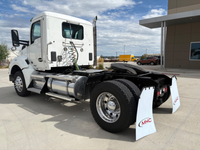 Kenworth T880 tractor cab and chassis showing rear view with connected air lines and fuel tanks, front wheel, and MHC mud flaps.