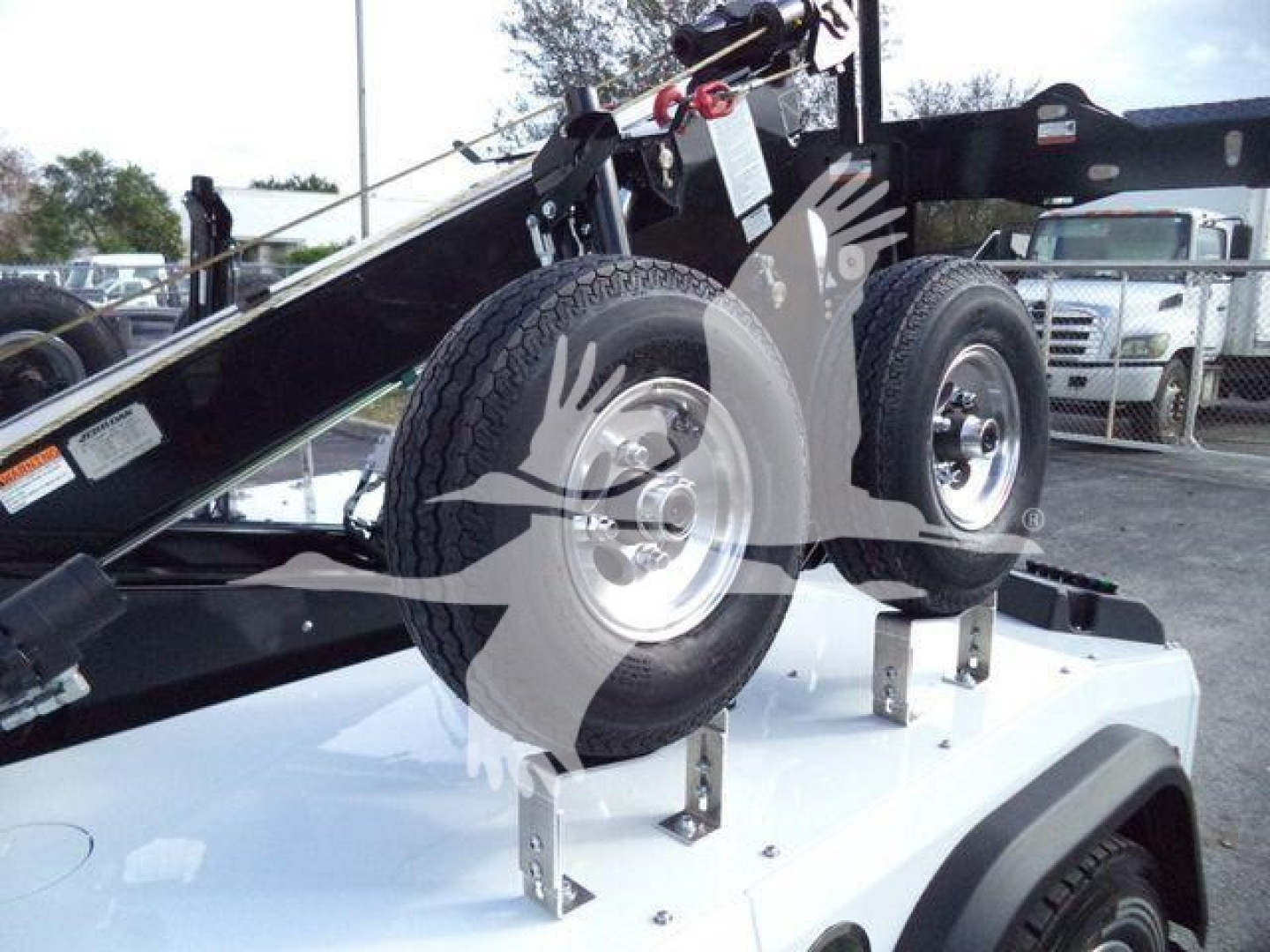 Truck equipment showing dual spare tires mounted on a white Silverado chassis with winch gear and black frame components.