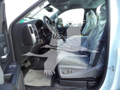 Truck interior of a 2023 Chevrolet Silverado 6500HD showing front seats and dashboard with plastic coverings on seats.