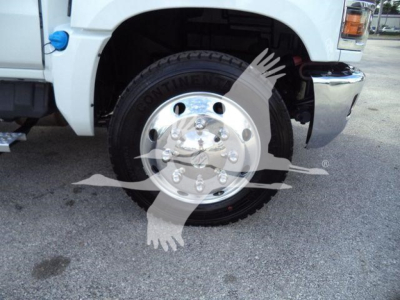 Pickup truck front wheel area showing Continental tire and chrome hub on white Chevrolet Silverado 6500HD chassis.